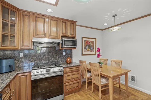 a kitchen with granite countertop wooden cabinets and stainless steel appliances