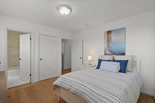 a bedroom with a bed and a painting on the wall