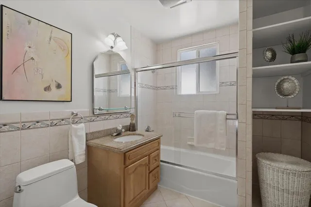 a bathroom with a granite countertop sink a toilet and shower