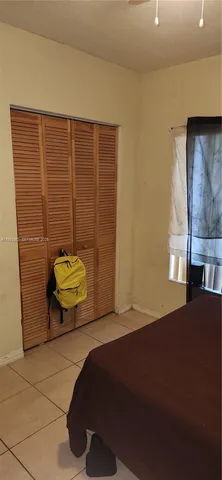 a bedroom with a bed and a potted plant