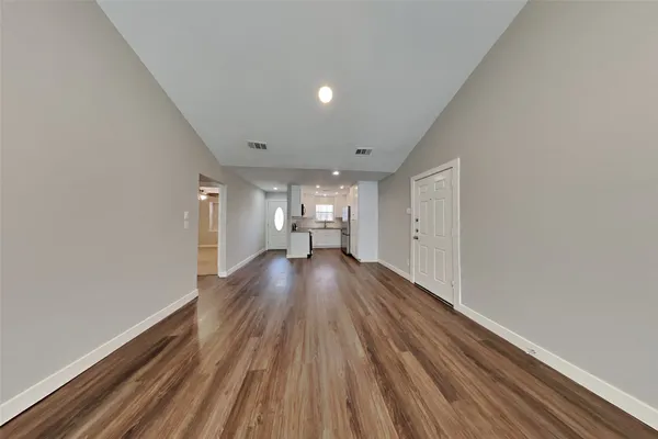 a view of empty room with wooden floor