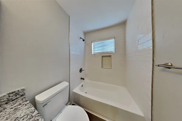 a bathroom with a toilet and a bathtub