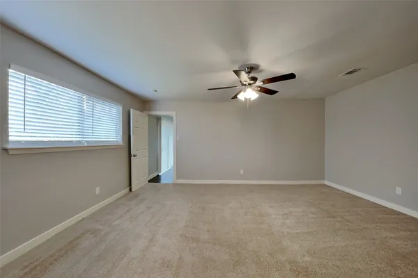 a view of an empty room with a ceiling fan