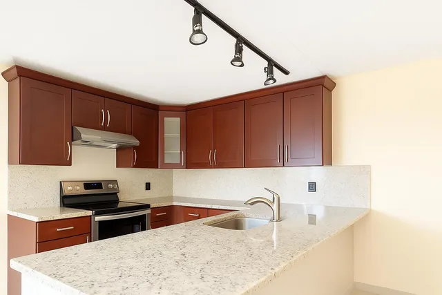 a kitchen with stainless steel appliances granite countertop a sink stove and cabinets