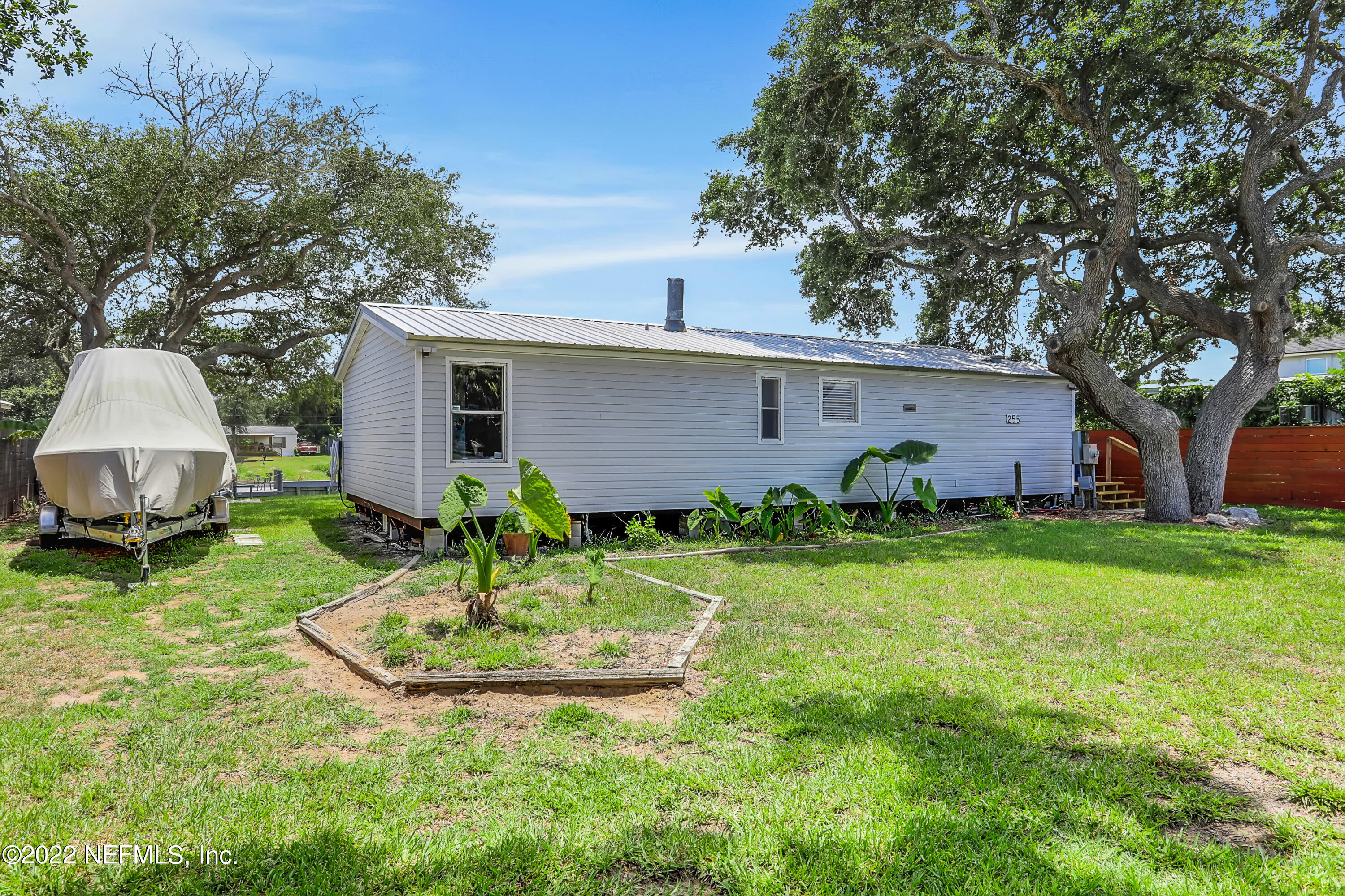 255 Villa Verda Road St. Augustine, FL 32080 - Photo 27 of 36 a backyard of a house with table and chairs plants and large tree