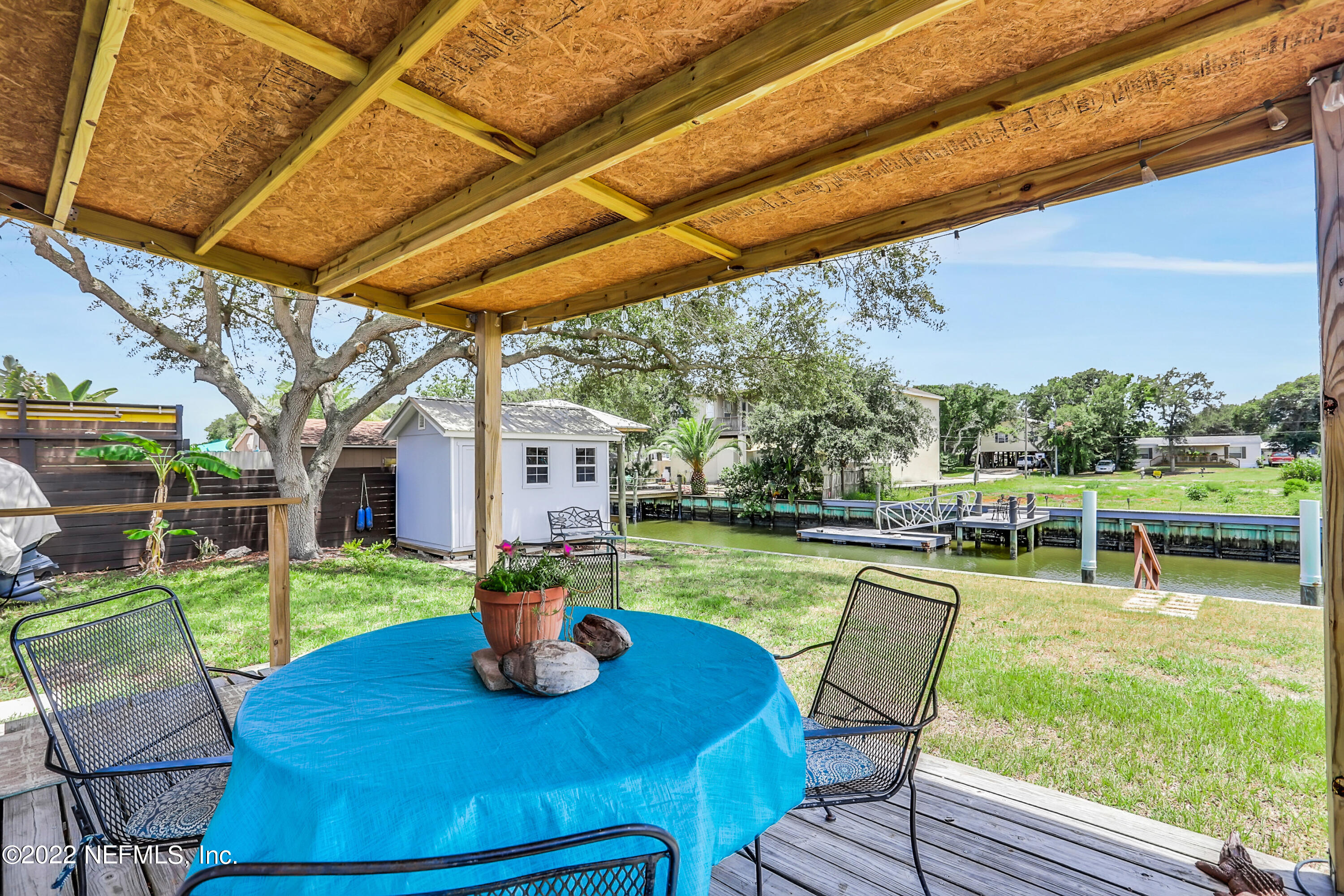 255 Villa Verda Road St. Augustine, FL 32080 - Photo 28 of 36 a view of a backyard with table and chairs potted plants and a palm tree