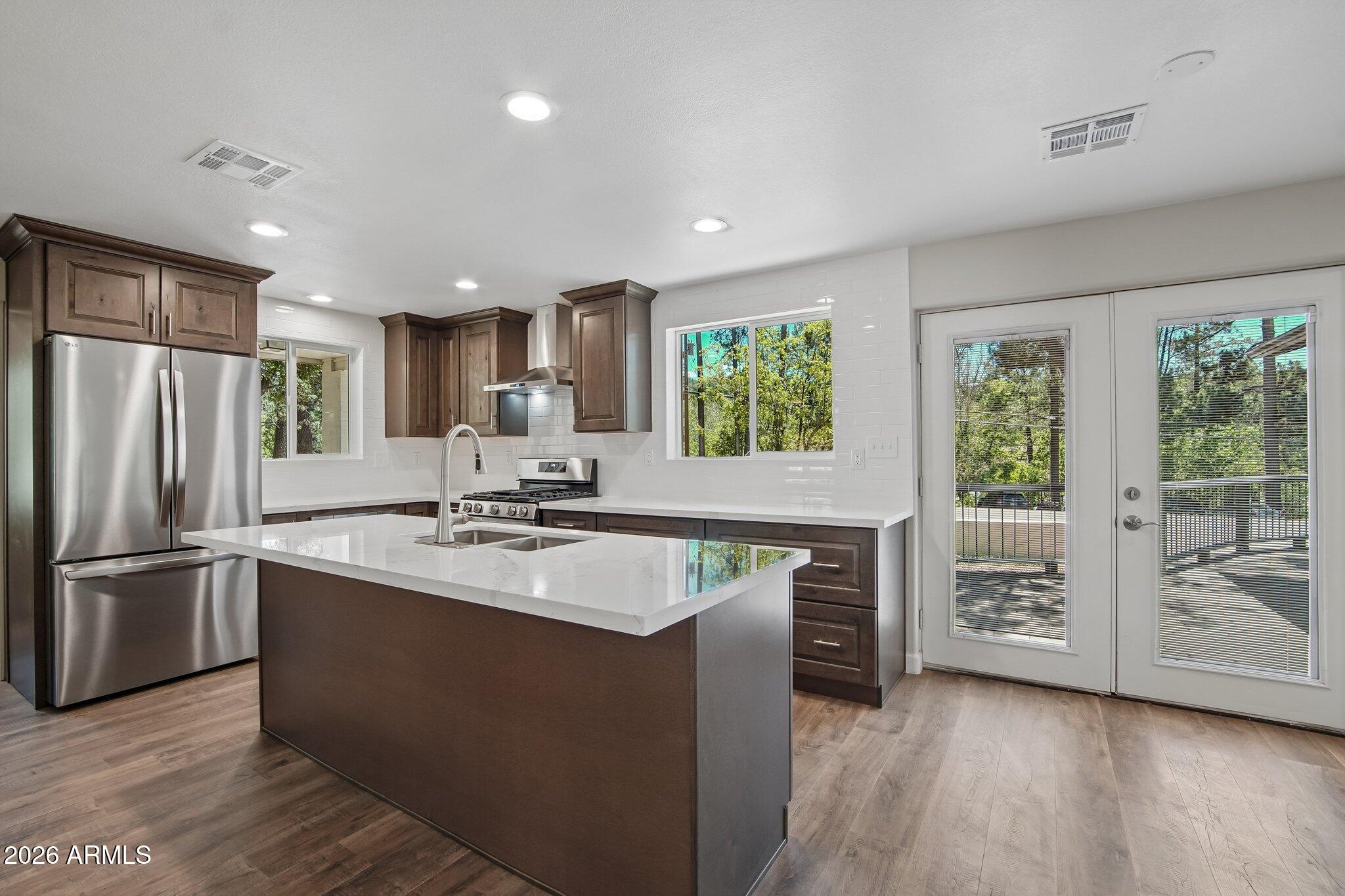 8324 Fossil Creek Road Pine, AZ 85544 - Photo 11 of 29 a large kitchen with stainless steel appliances granite countertop a refrigerator a stove a sink and a microwave