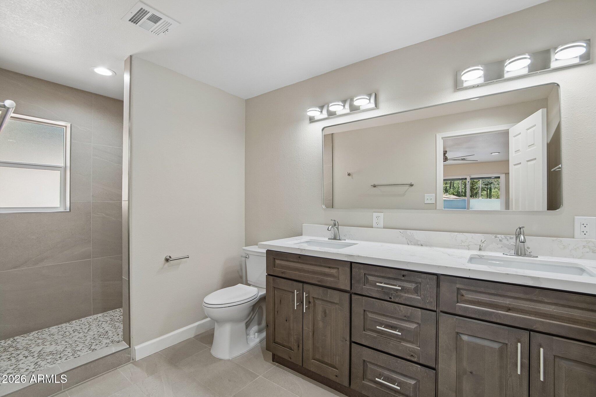 8324 Fossil Creek Road Pine, AZ 85544 - Photo 13 of 29 a bathroom with a granite countertop sink a toilet and a mirror