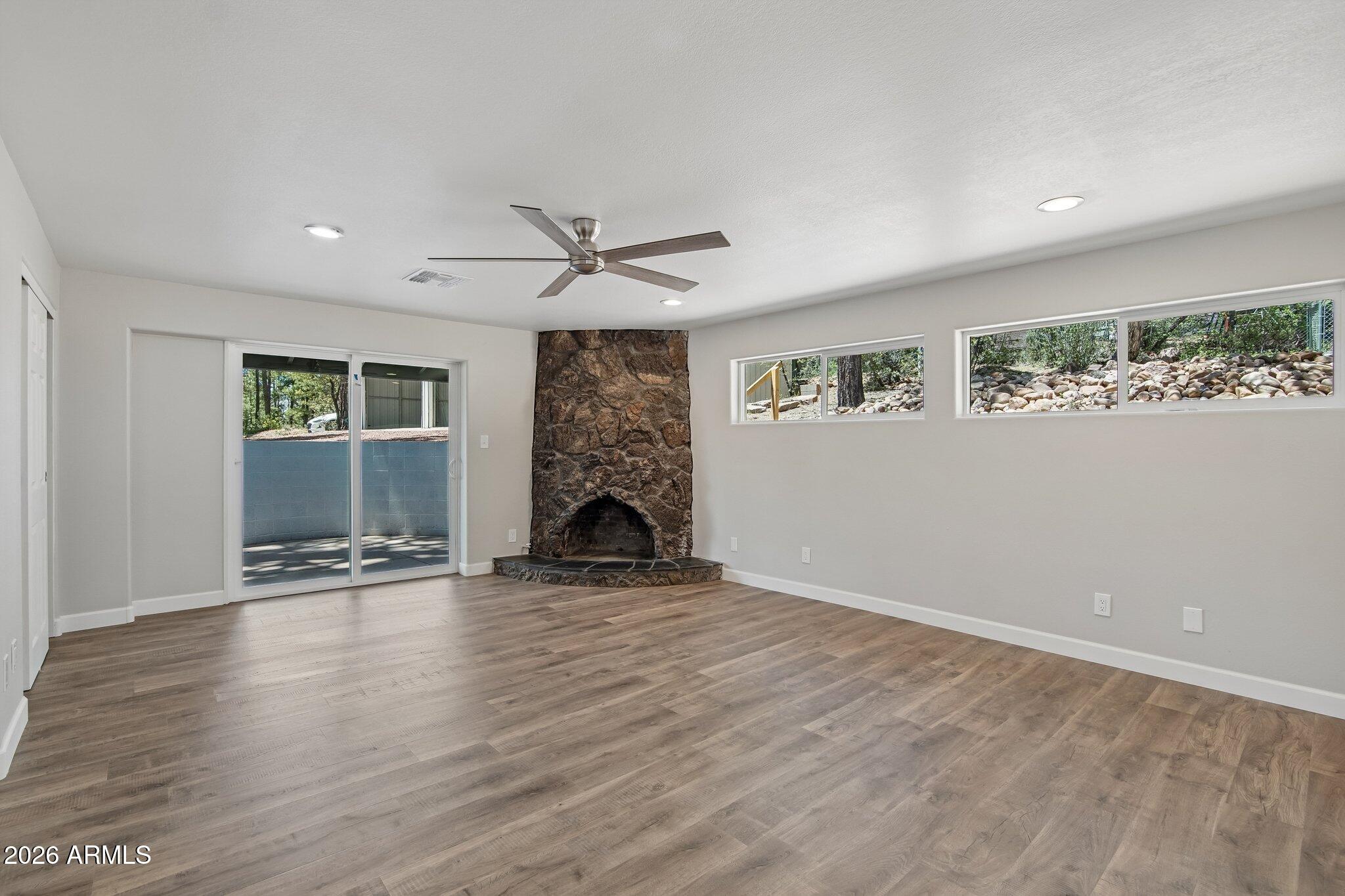 8324 Fossil Creek Road Pine, AZ 85544 - Photo 16 of 29 an empty room with wooden floor and windows