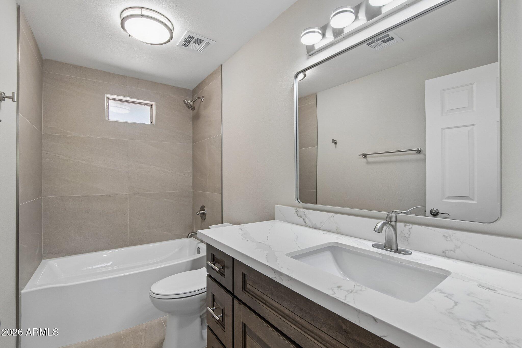 8324 Fossil Creek Road Pine, AZ 85544 - Photo 19 of 29 a bathroom with a granite countertop sink a toilet a mirror and shower