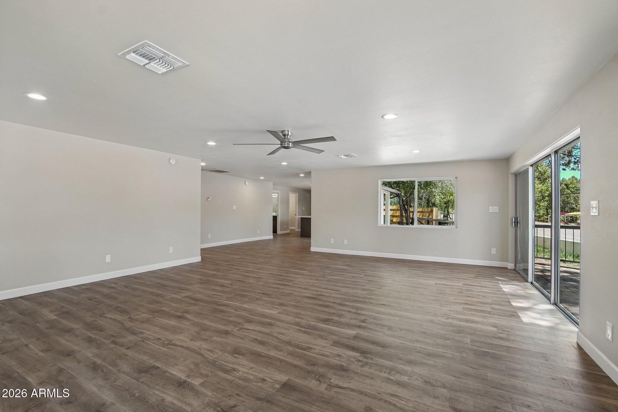 8324 Fossil Creek Road Pine, AZ 85544 - Photo 8 of 29 an empty room with wooden floor and windows