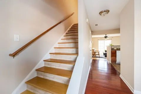 a view of a hallway with wooden floor and staircase