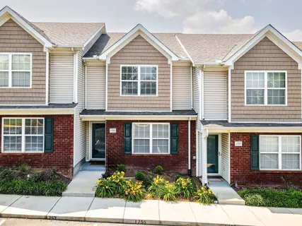 front view of a brick house and a small yard