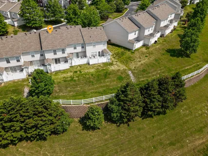 an aerial view of residential houses with outdoor space and trees