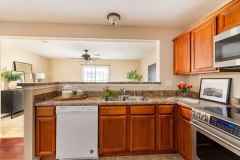 a kitchen with granite countertop a sink stove and cabinets
