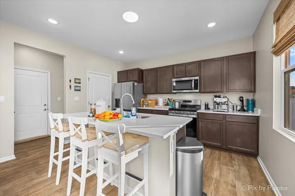 a kitchen with stainless steel appliances granite countertop a stove top oven a sink dishwasher and a refrigerator