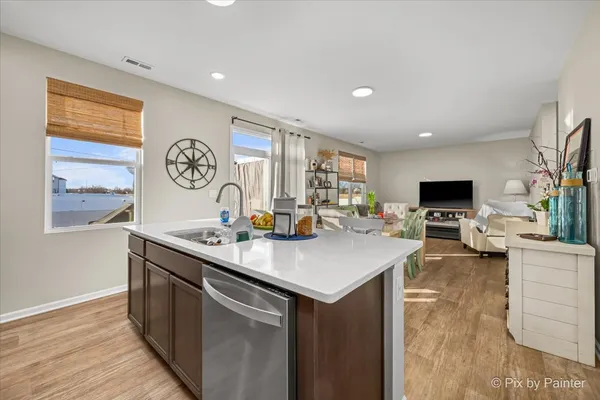 a view of kitchen island with stainless steel appliances granite countertop a sink and a stove