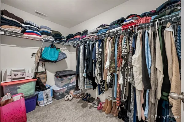 a view of walk in closet with clothes