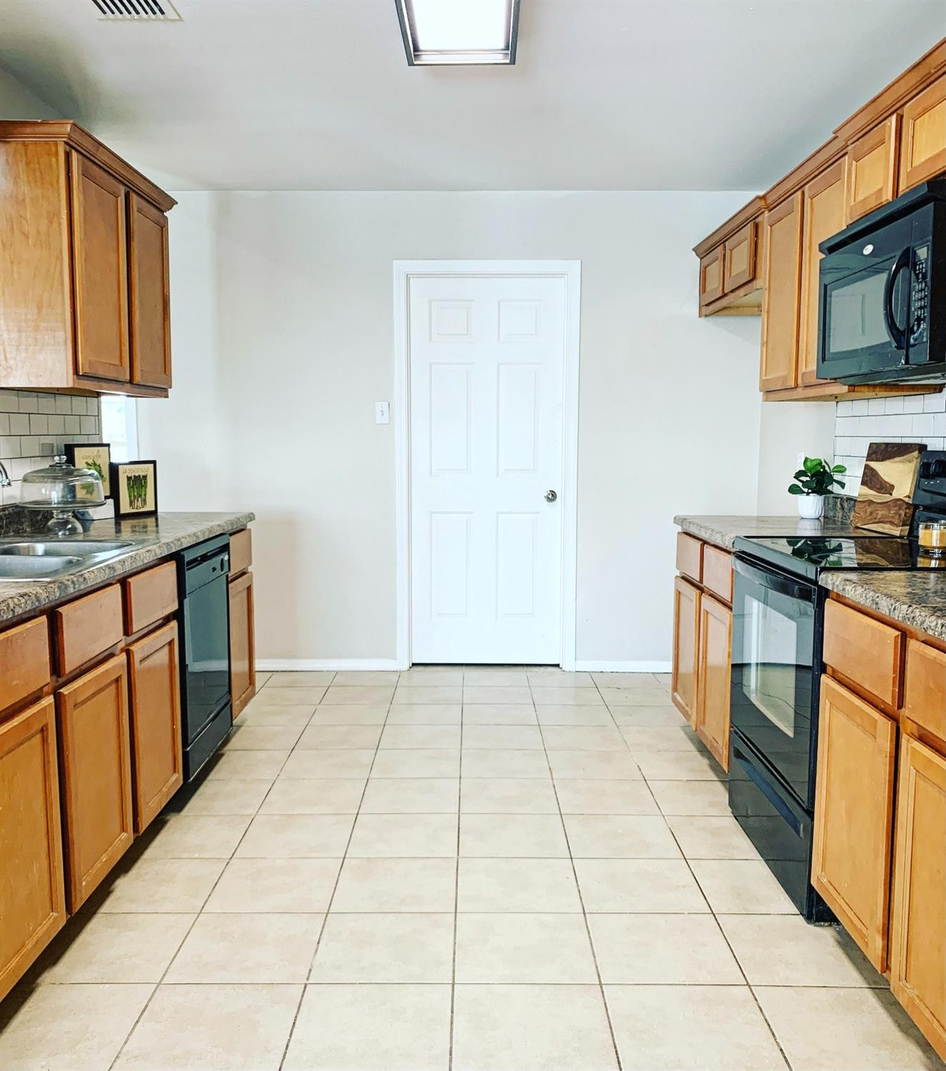 9807 Juneau Avenue Lubbock, TX 79424 - Photo 6 of 22 a kitchen with stainless steel appliances granite countertop a stove a sink and a microwave