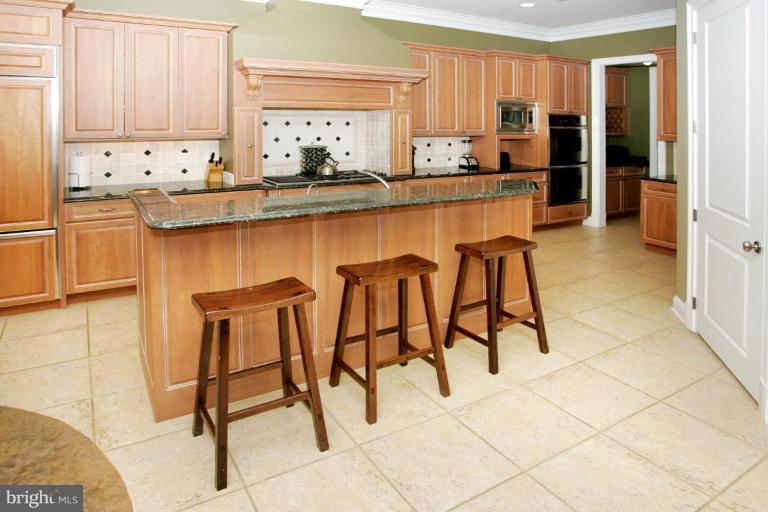7105 Exfair Road Bethesda, MD 20814 - Photo 15 of 24 a kitchen with stainless steel appliances kitchen island granite countertop a refrigerator and a stove top oven