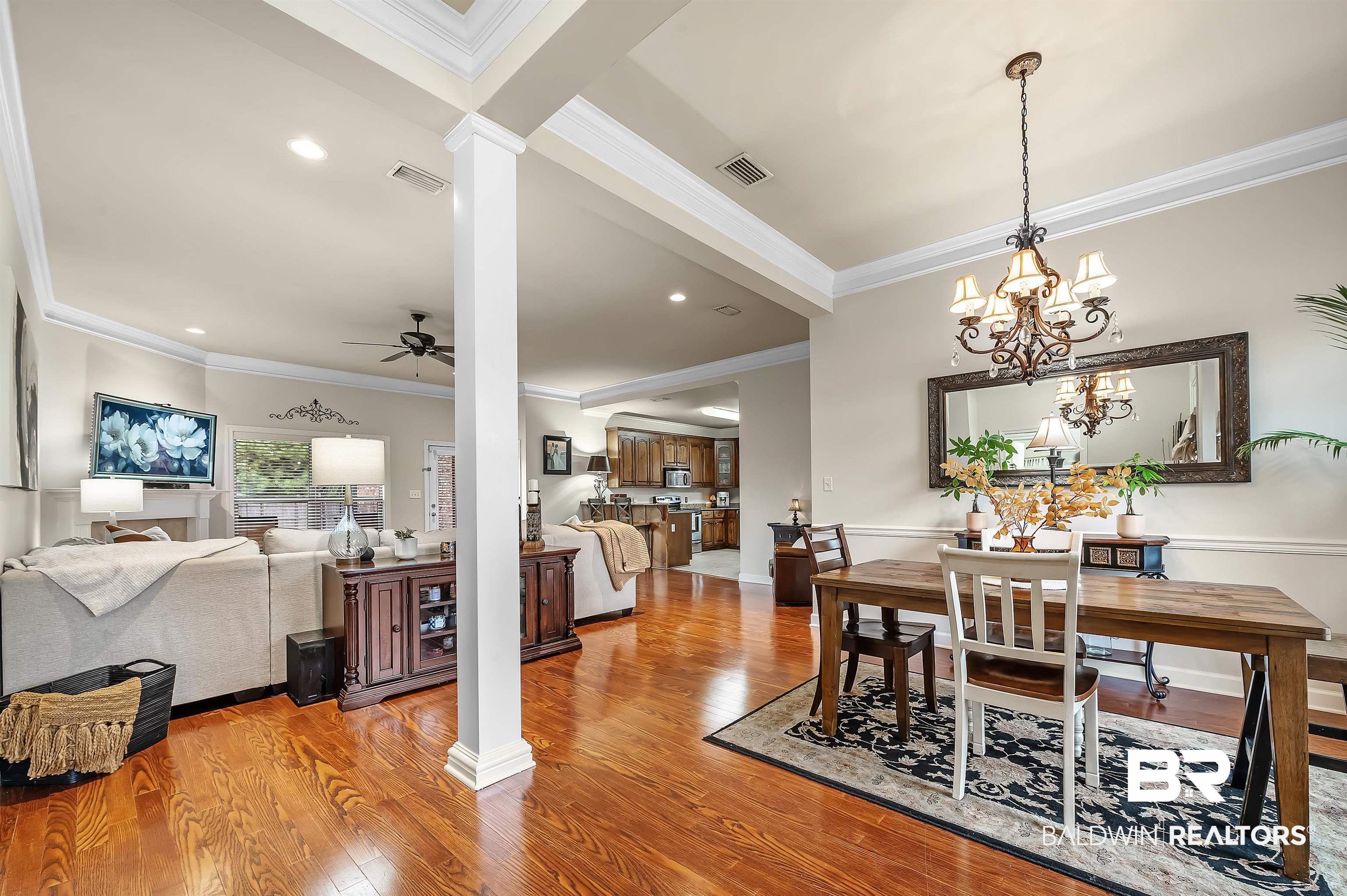 9376 Sable Court Daphne, AL 36526 - Photo 18 of 46 Dining area featuring crown molding, hardwood / wood-style floors, ceiling fan with notable chandelier, and decorative columns