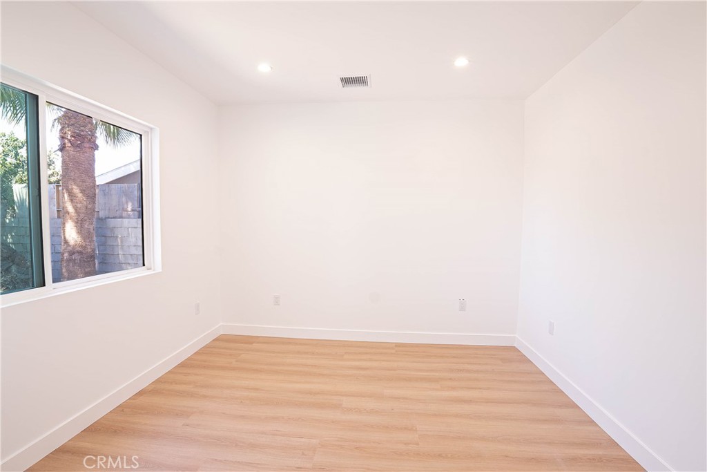 13003 Kamloops Street Pacoima, CA 91331 - Photo 18 of 66 a view of an empty room with wooden floor and a window