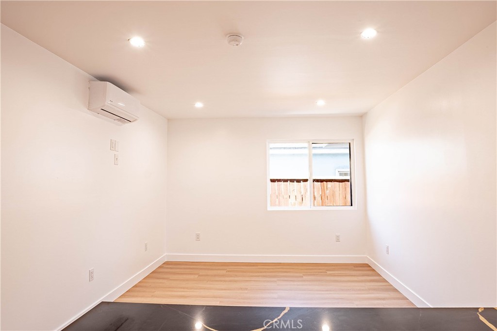 13003 Kamloops Street Pacoima, CA 91331 - Photo 27 of 66 an empty room with wooden floor and windows