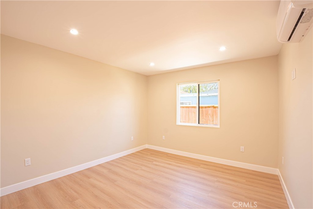 13003 Kamloops Street Pacoima, CA 91331 - Photo 28 of 66 an empty room with wooden floor and windows