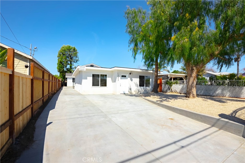 13003 Kamloops Street Pacoima, CA 91331 - Photo 3 of 66 a view of a white house with a yard and potted plants