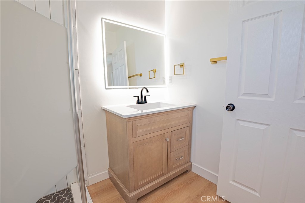 13003 Kamloops Street Pacoima, CA 91331 - Photo 42 of 66 a bathroom with a sink a mirror and a shower