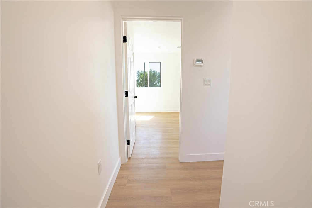 13003 Kamloops Street Pacoima, CA 91331 - Photo 44 of 66 a view of a hallway with wooden floor