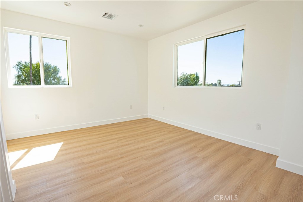 13003 Kamloops Street Pacoima, CA 91331 - Photo 45 of 66 an empty room with wooden floor and a window