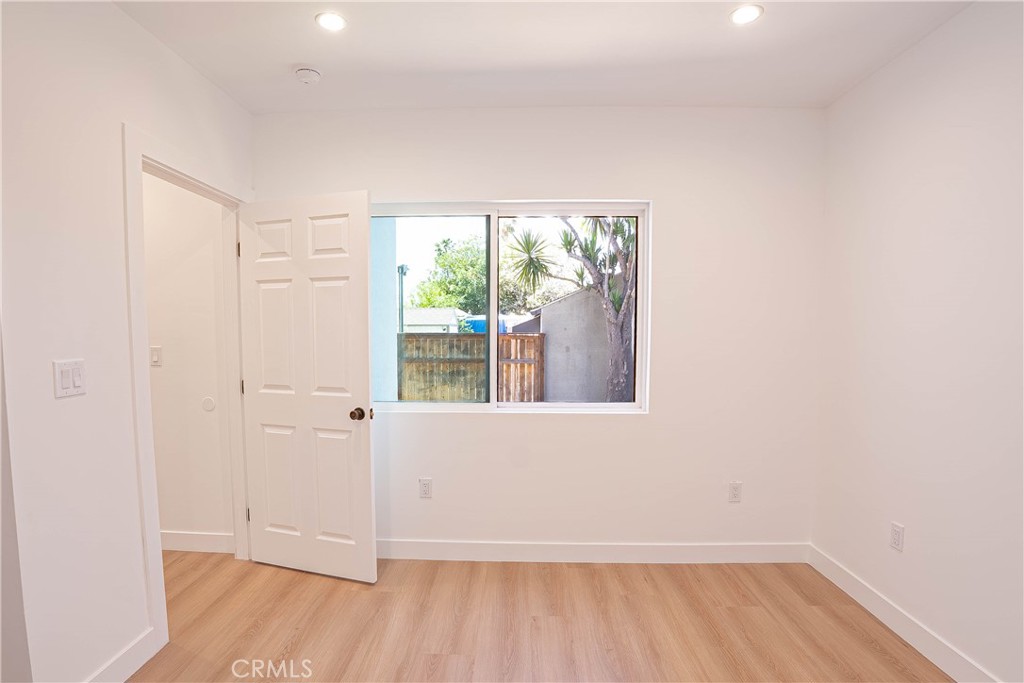 13003 Kamloops Street Pacoima, CA 91331 - Photo 49 of 66 a view of an empty room with wooden floor and a window