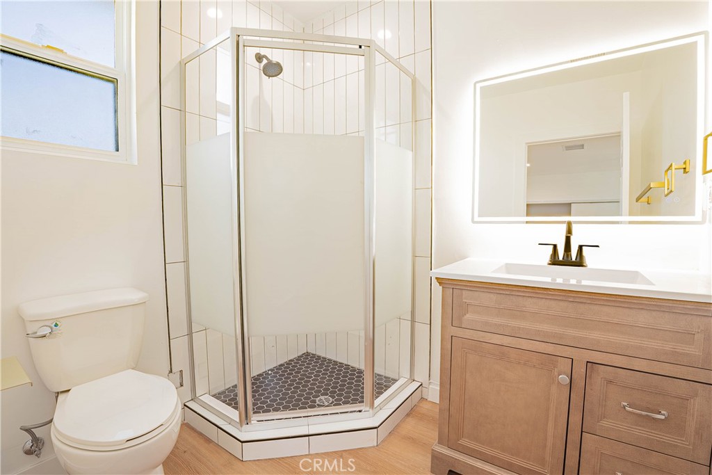 13003 Kamloops Street Pacoima, CA 91331 - Photo 54 of 66 a bathroom with a shower a mirror a toilet and a sink