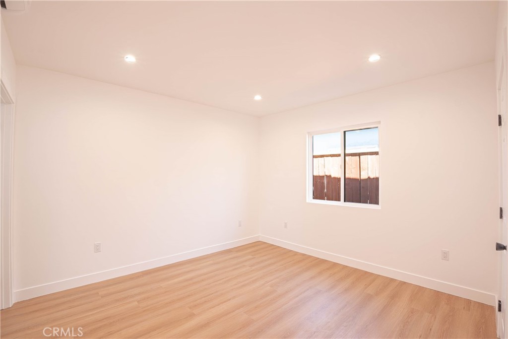 13003 Kamloops Street Pacoima, CA 91331 - Photo 55 of 66 an empty room with wooden floor and windows
