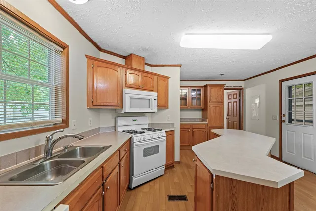 a kitchen with a sink stove top oven and refrigerator