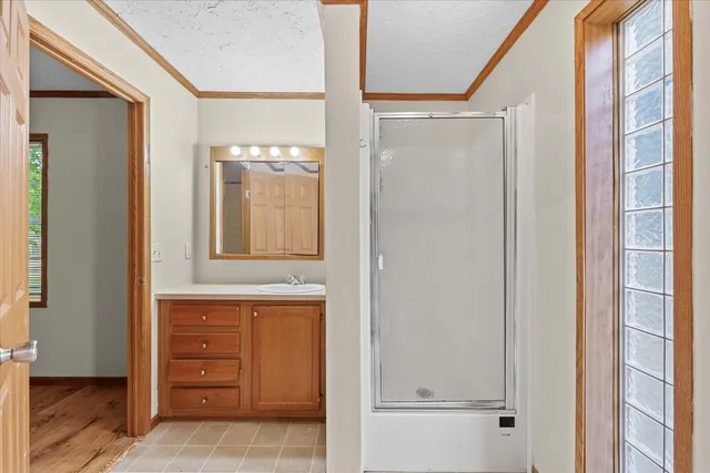 a bathroom with a shower a mirror and a sink