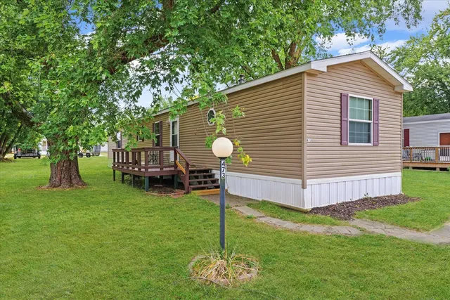 a view of a house with backyard and a tree