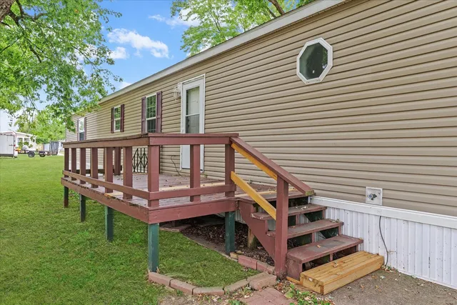 a view of a house with wooden deck and a yard