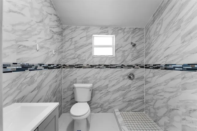 a bathroom with a toilet a sink and a window