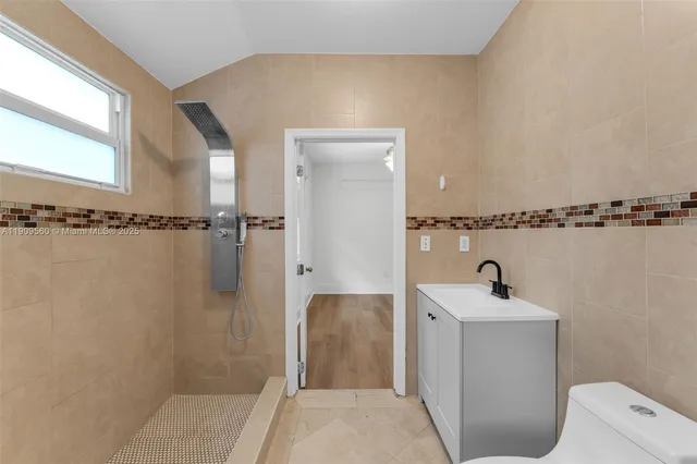 a bathroom with a sink a toilet and shower