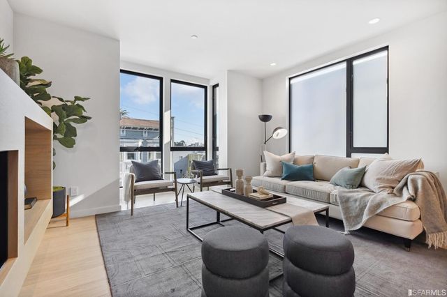 a living room with furniture large window and a table