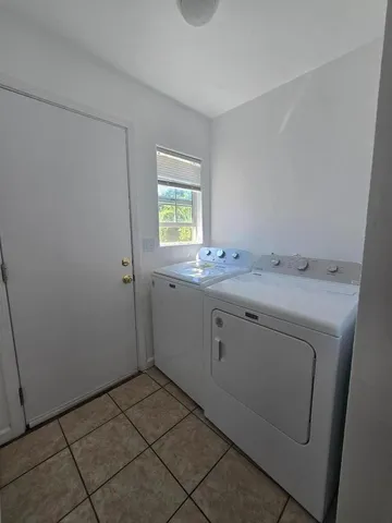 a utility room with a sink a cabinetry and a window