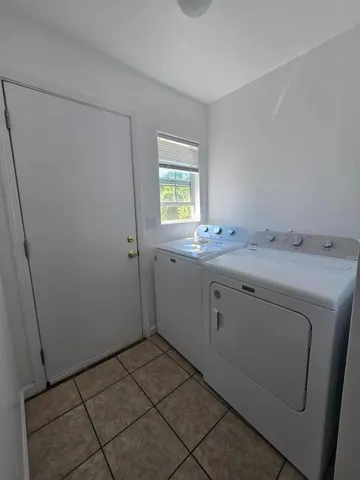 a utility room with cabinets washer and dryer