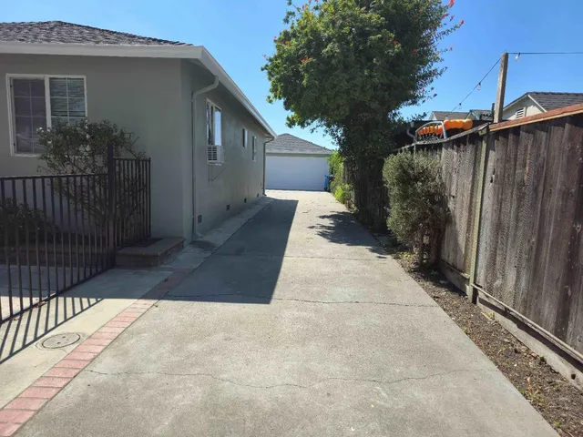 a view of a pathway of house with wooden fence