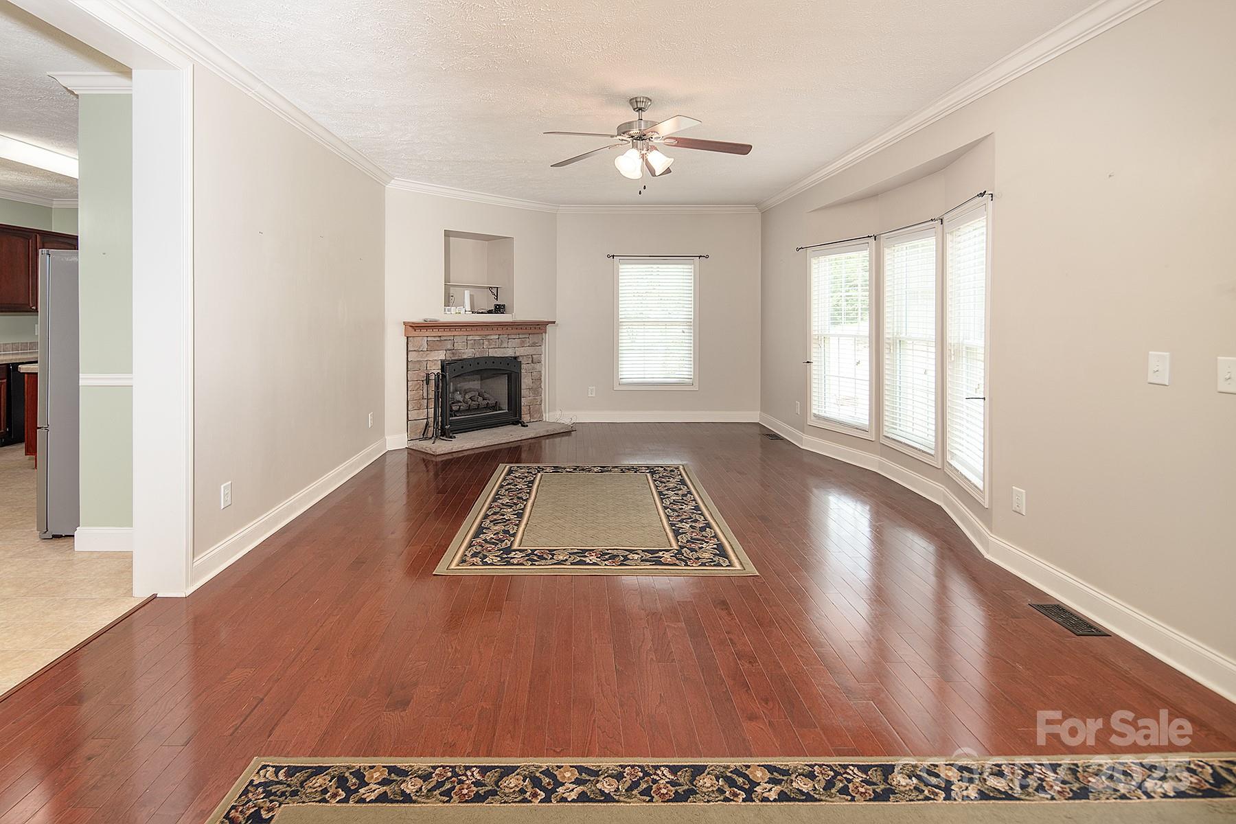 366 Lakehurst Farm Road Norwood, NC 28128 - Photo 17 of 46 wooden floor in an empty room with a fireplace