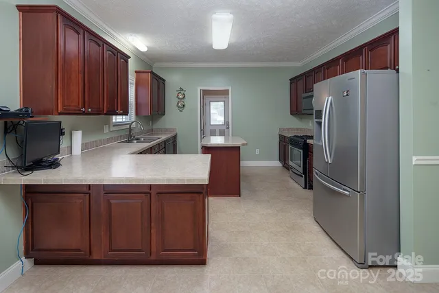 a kitchen with a refrigerator sink and cabinets