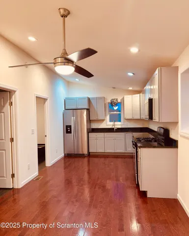 a kitchen with stainless steel appliances granite countertop a refrigerator a sink and a stove