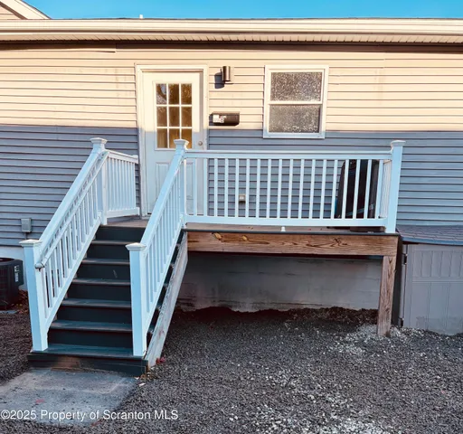 a living room with stainless steel appliances kitchen island granite countertop furniture and a wooden floor