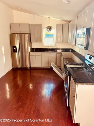 a room with a wooden floor and a potted plant